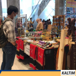 Salah satu pengunjung yang sedang melihat kerajinan khas Kalimantan Timur.