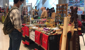 Salah satu pengunjung yang sedang melihat kerajinan khas Kalimantan Timur.
