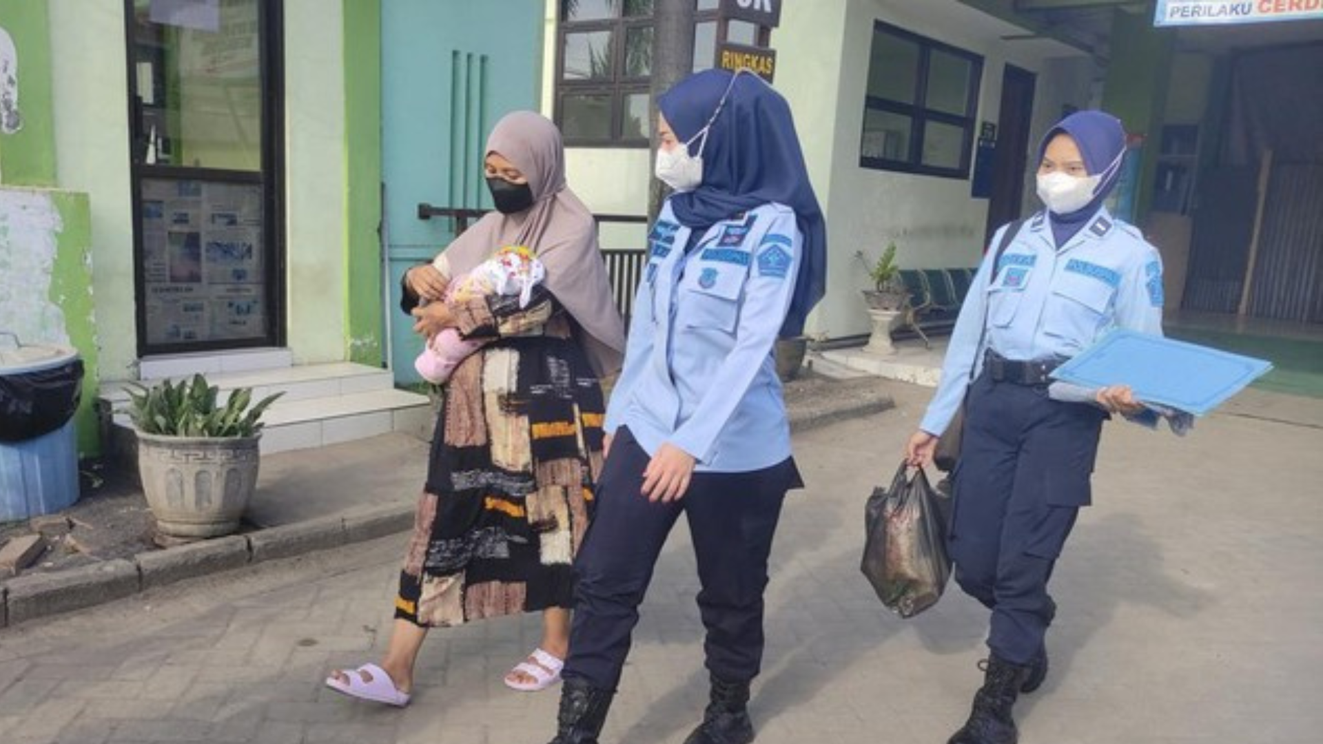 Foto : AV bersama sang bayi saat dikawal oleh petugas kembali ke rutan. Sumber Foto : Istimewa.